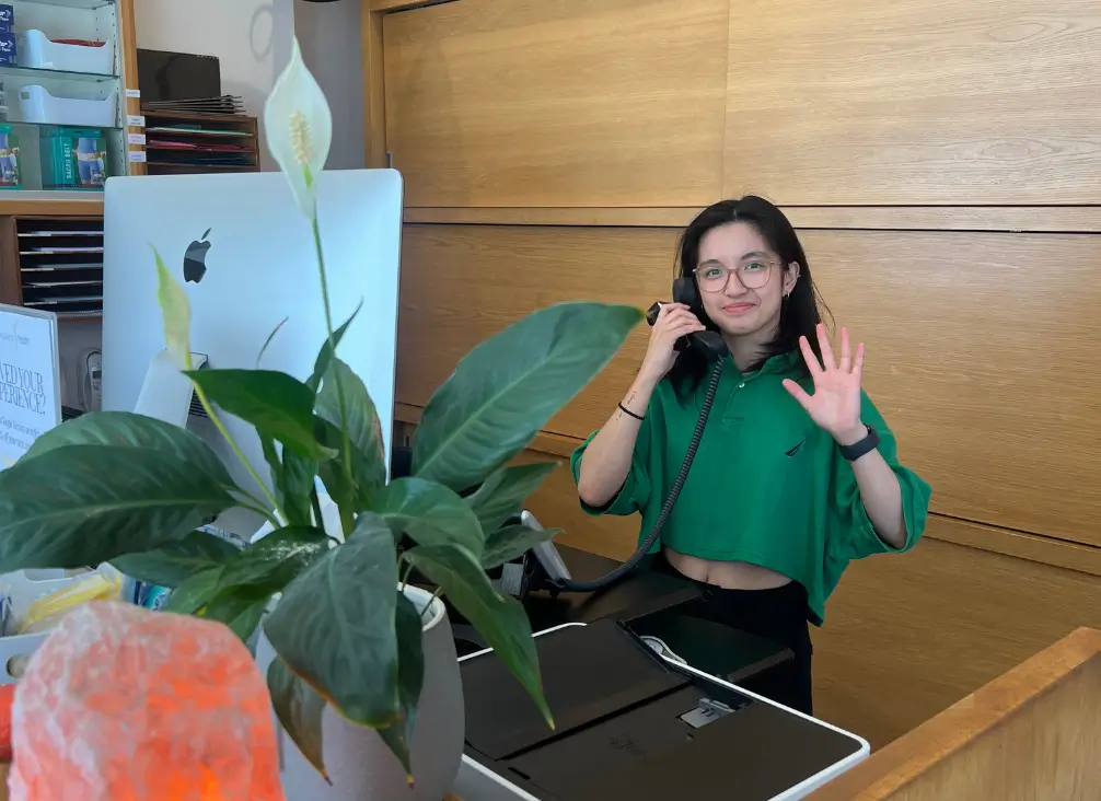 Friendly receptionist waving at Chiropractor Melbourne's patients
