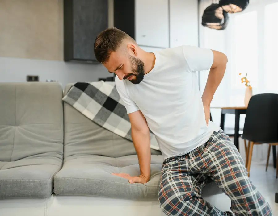Man experiencing sciatica pain in lower back at home