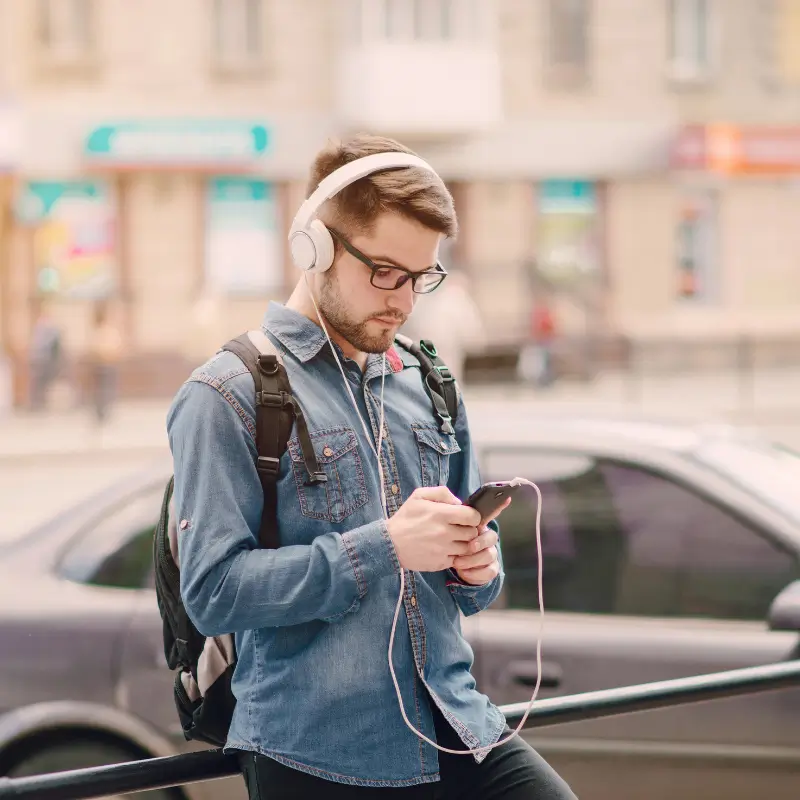 Young man with poor posture using phone – tech neck pain relief from Chiropractor Melbourne
