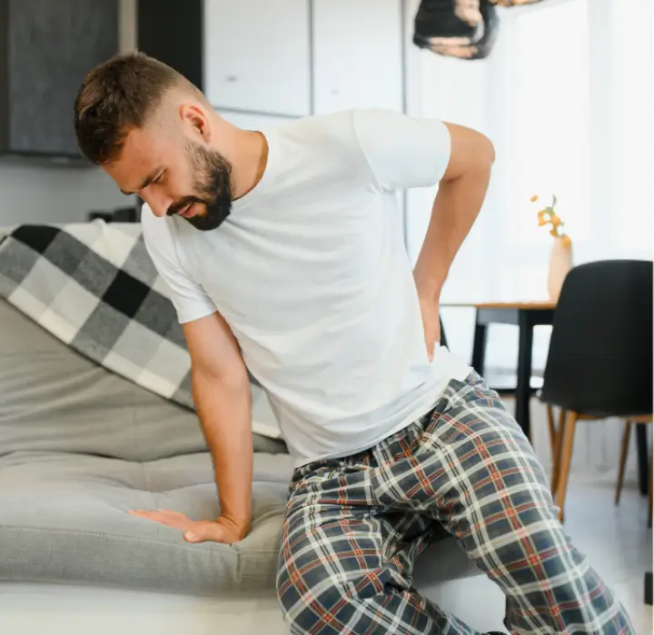 Man experiencing sciatica pain in lower back at home