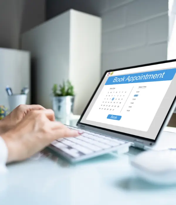 Person booking a colonic hydrotherapy appointment online using a laptop