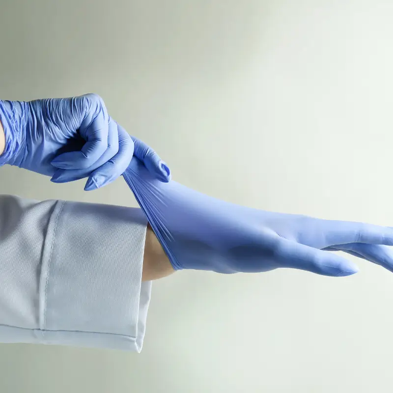 Colonic hydrotherapist putting on medical gloves for hygienic colonic irrigation