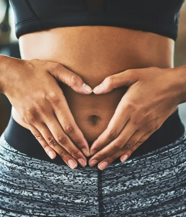 Person forming heart shape over abdomen to symbolise gut health