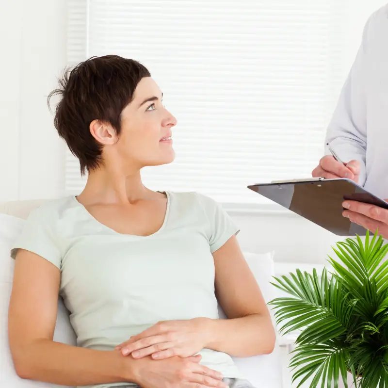 Woman receiving consultation before colonic hydrotherapy treatment