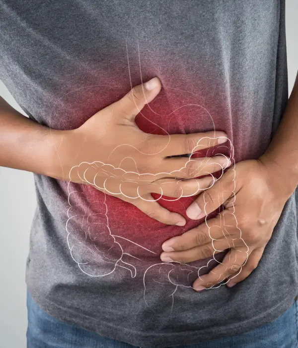 Person clutching stomach in discomfort with colon illustration overlay – digestive relief through colonic irrigation